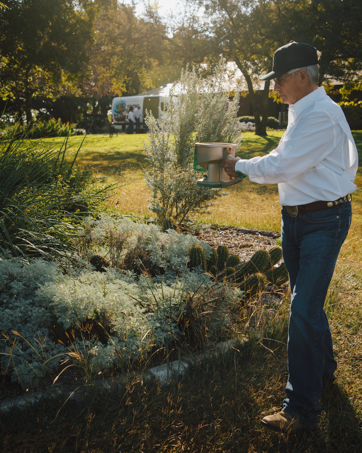 Technician applying fire ant bait with a hand spreader
